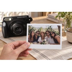 Tirage Instax Wide tenu en main devant un Wide 210 noir